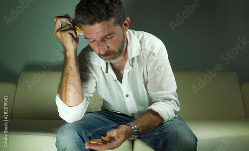 Quadro em tela dramatic portrait of young attractive depressed and wasted pills addict man hold