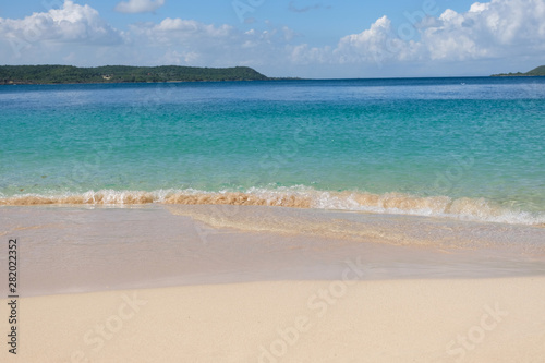 Tropical sandy beach in caribbean with an island on the horizon. © Maxim