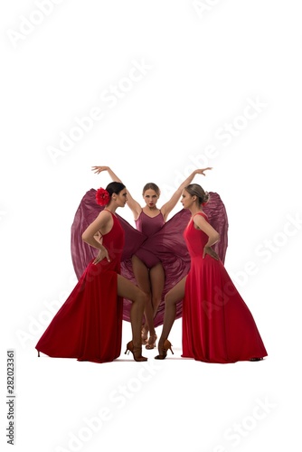 Young women in red dresses dancing passionate dance