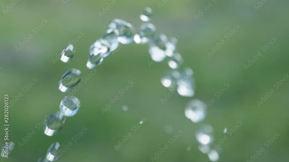 Pure water droplets passing camera in Slowmotion with green background - 180fps Pure water droplets passing camera in Slowmotion with green background - 180fps