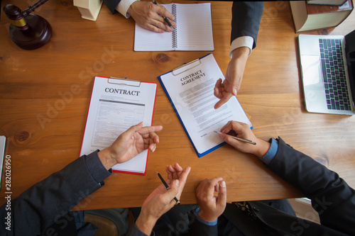 Grupa ludzie biznesu i prawnicy dyskutuje kontraktacyjnych papiery, konsultacja między męskim prawnikiem i biznesmena pojęcie
