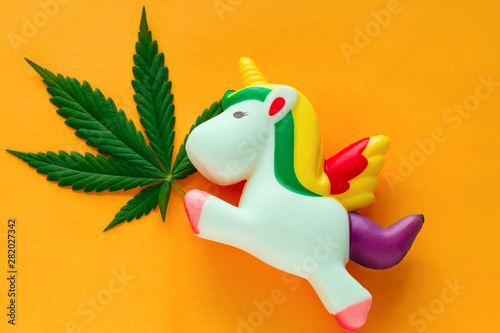 top view unicorn with marijuana green leaf on a vibrant yellow background