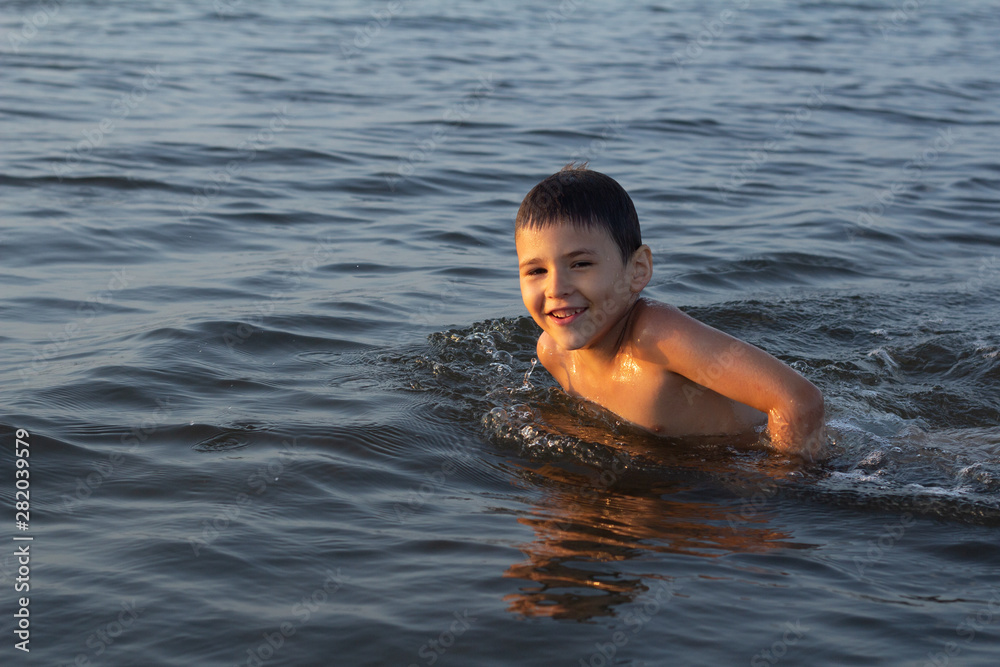 little boy swims in the sea