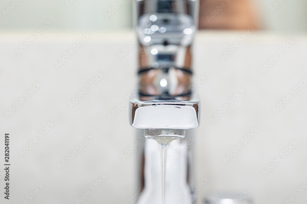 A drop of water dripping from the tap.