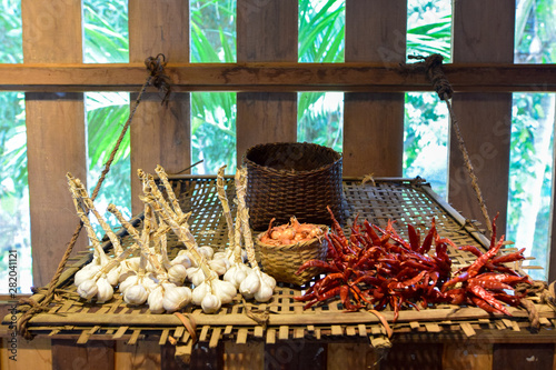 Wooden kitchen, dried red pepper and garlic on bamboo weave © Witthawas