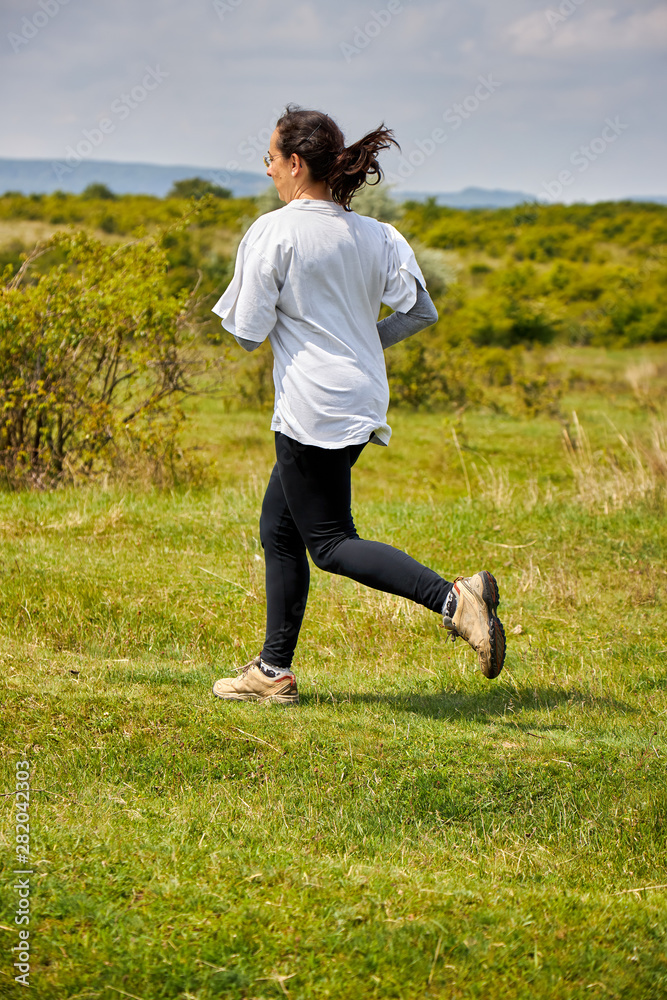 Spanish woman running on meadow Spanish woman running on meadow
