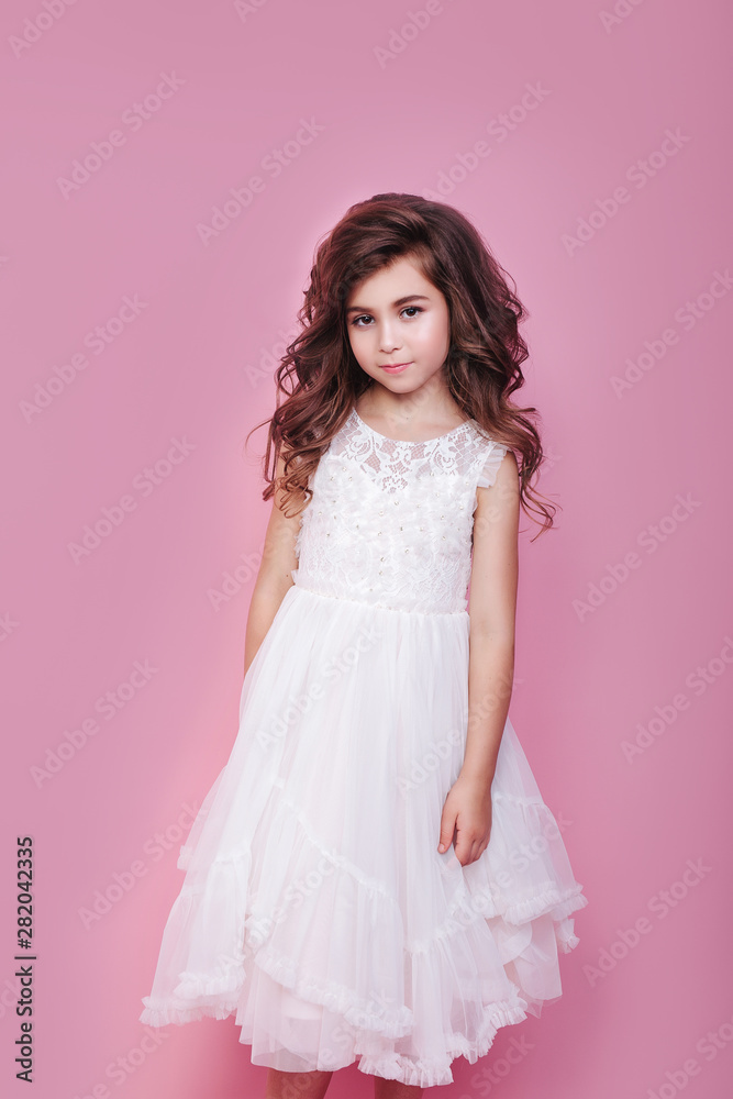portrait of beautiful little girl in white dress on pink background portrait of beautiful little girl in white dress on pink background