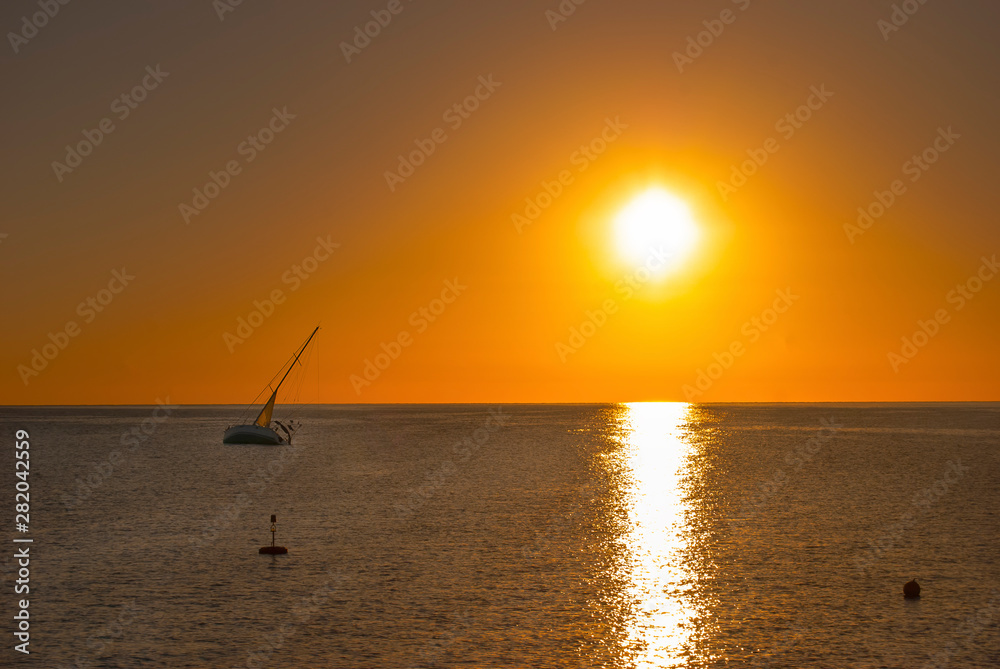 Sunrise over the Red Sea and the silhouette of an abandoned boat in Port Ghalib, Egypt