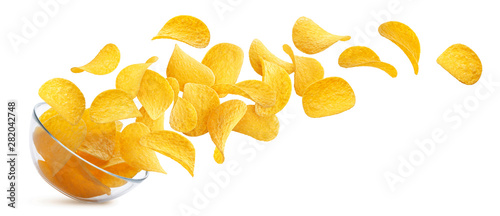 Potato chips falling into glass bowl isolated on white background photo