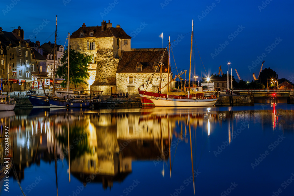 Obraz premium View of the picturesque harbour of Honfleur, yachts and old houses reflected in water. Blue hours. France, Normandy, Europe.