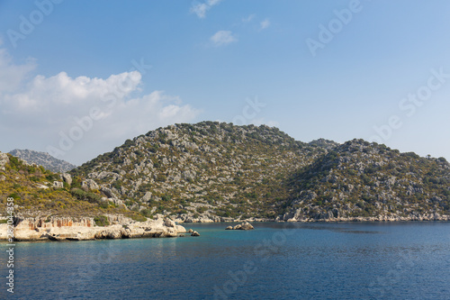 Mediterranean sea overlooking the mountains. Aerial top view of sea waves hitting rocks on the beach with turquoise sea water. Amazing rock cliff seascape in the coastline. © stas_malyarevsky