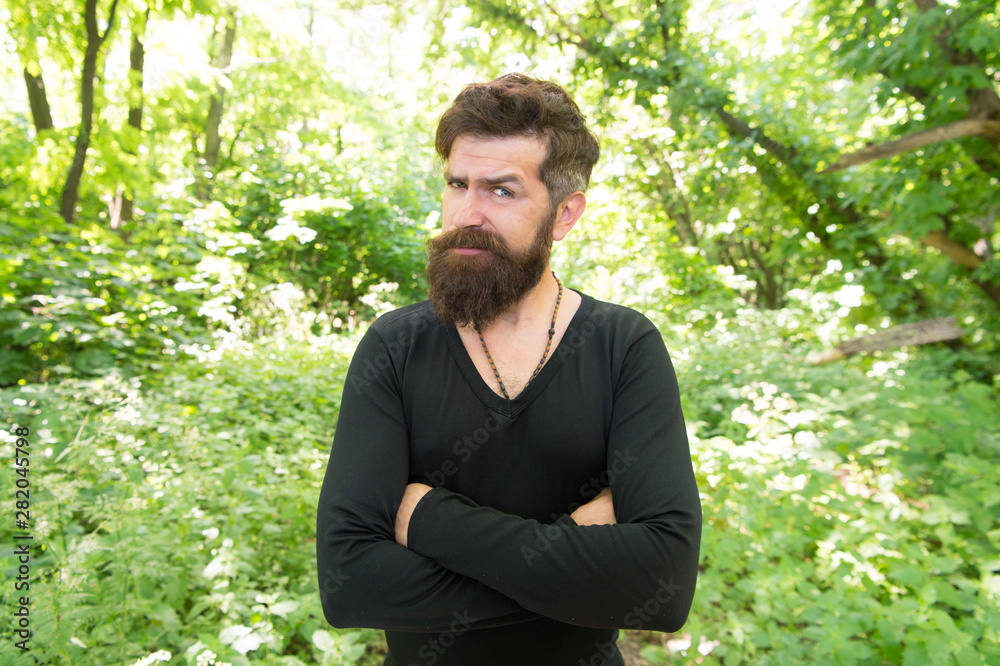 His beard style looks great. Brutal hipster wearing fashionable mustache and beard hair style. Bearded man keeping arms crossed in casual style on summer day. There is style for every man His beard style looks great. Brutal hipster wearing fashionable mustache and beard hair style. Bearded man keeping arms crossed in casual style on summer day. There is style for every man