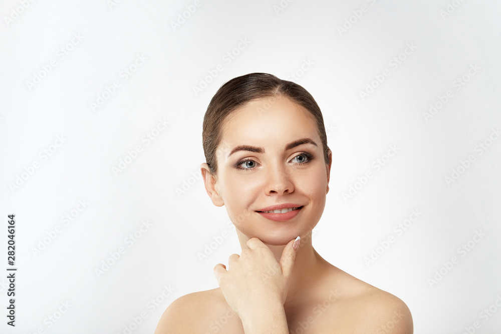 Beautiful Young Woman with Clean Fresh Skin touch own face. Facial treatment. Cosmetology, beauty and spa. Skin care. Model With Natural Makeup