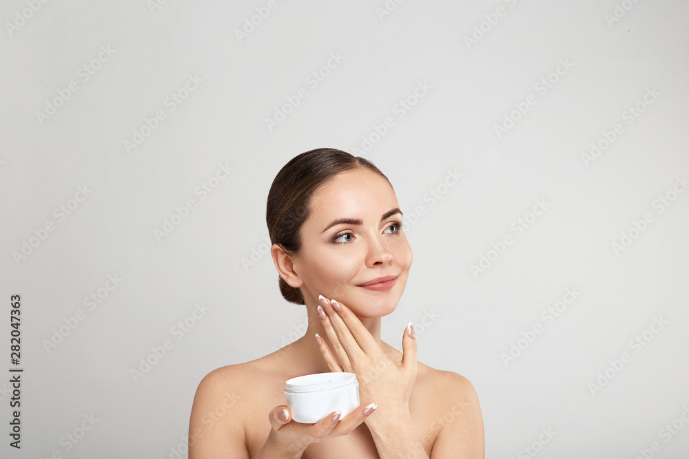 Beautiful Young Woman with Clean Fresh Skin touch own face. Girl holdinging and apply moisturizing cream. Facial treatment. Skin care. Cosmetology, beauty and spa. Beautiful Young Woman with Clean Fresh Skin touch own face. Girl holdinging and apply moisturizing cream. Facial treatment. Skin care. Cosmetology, beauty and spa.