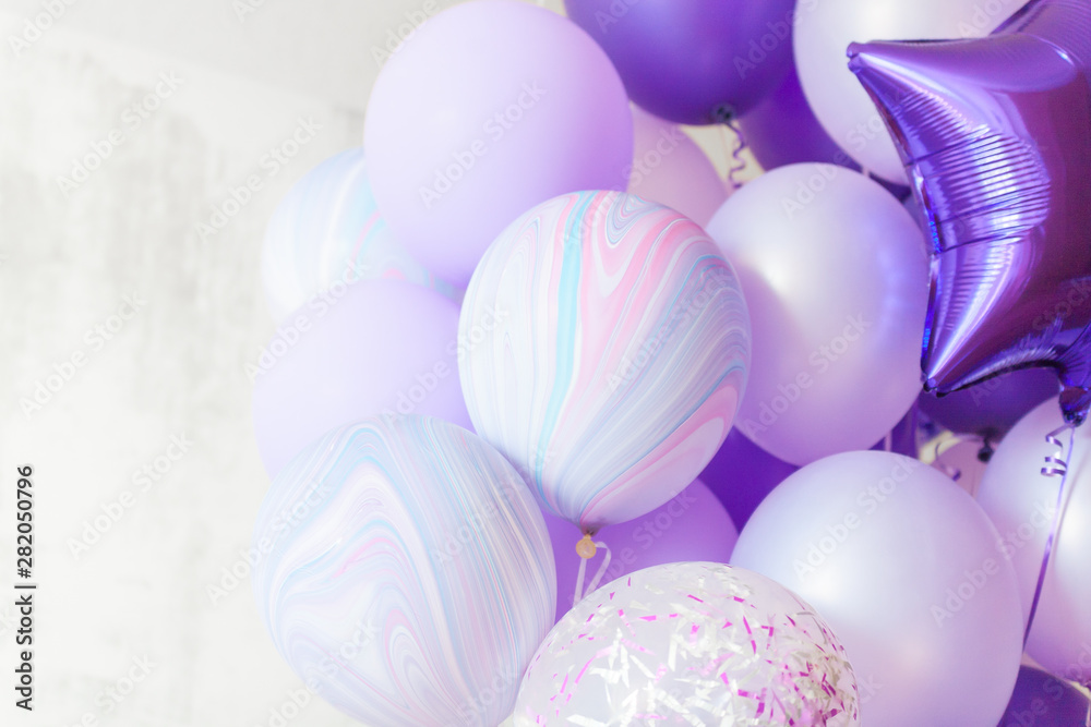 Flying purple and violet balloons on light gray background while  celebration. Birthday background with ballons. Stock Photo
