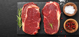 Raw meat, beef steak with spices on black background, top view.