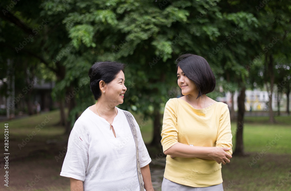 Senior asian older mother happy with daughter take care and support at outdoor Senior asian older mother happy with daughter take care and support at outdoor