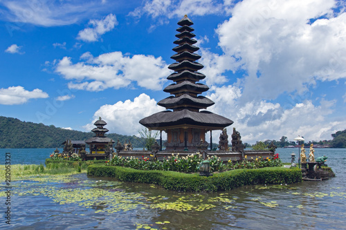 Pura Ulun Danu Bratan Temple in Bali. Hindu temple surrounded by flowers on Bratan lake, Bali. Water temple with blue sky in the background.
