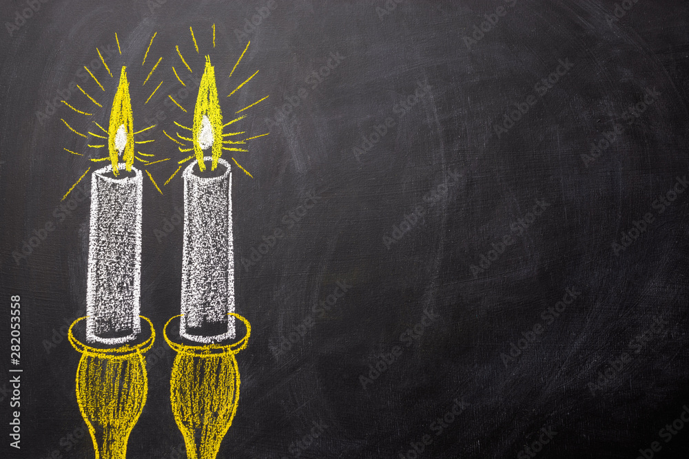 Two candles painted on a chalkboard with copy space.