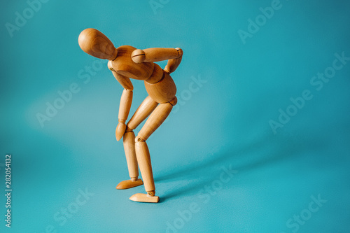 Concept of back pain. A wooden figure depicts a pain in the back. © Alrandir
