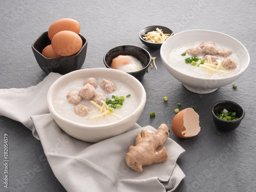 Rice congee with minced pork in white bowl. Bowl of rice porridge with soft boiled egg. Asian breakfast