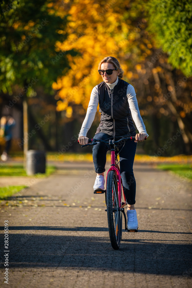 Urban biking - woman riding bike in city park