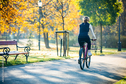 Urban biking - woman riding bike in city park