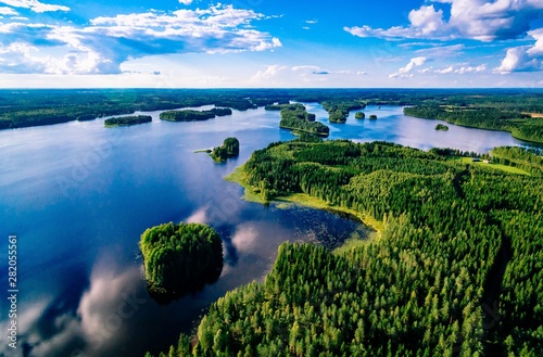 Aerial view of blue lakes and green forests on a sunny summer day in Finland from above