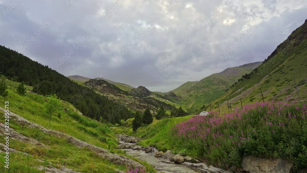 High mountain flowing water stream in Vall de Nuria, a part of the spanish Pyrenees. Timelapse view