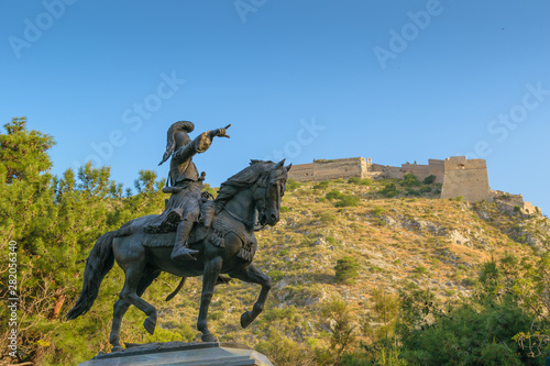 Theodore Kolokotronis statue with Palamidi castle in background in Nafplio, Greece © CoinUp