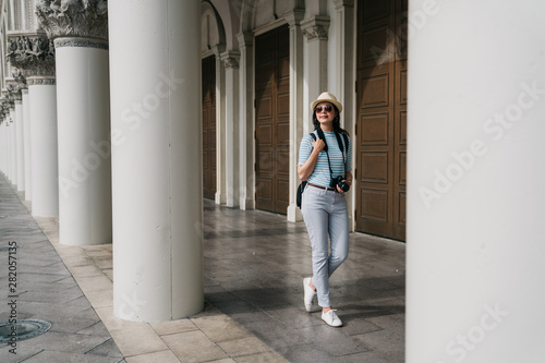 Slika na platnu full length of young female traveler sightseeing in foreign city on weekend overseas