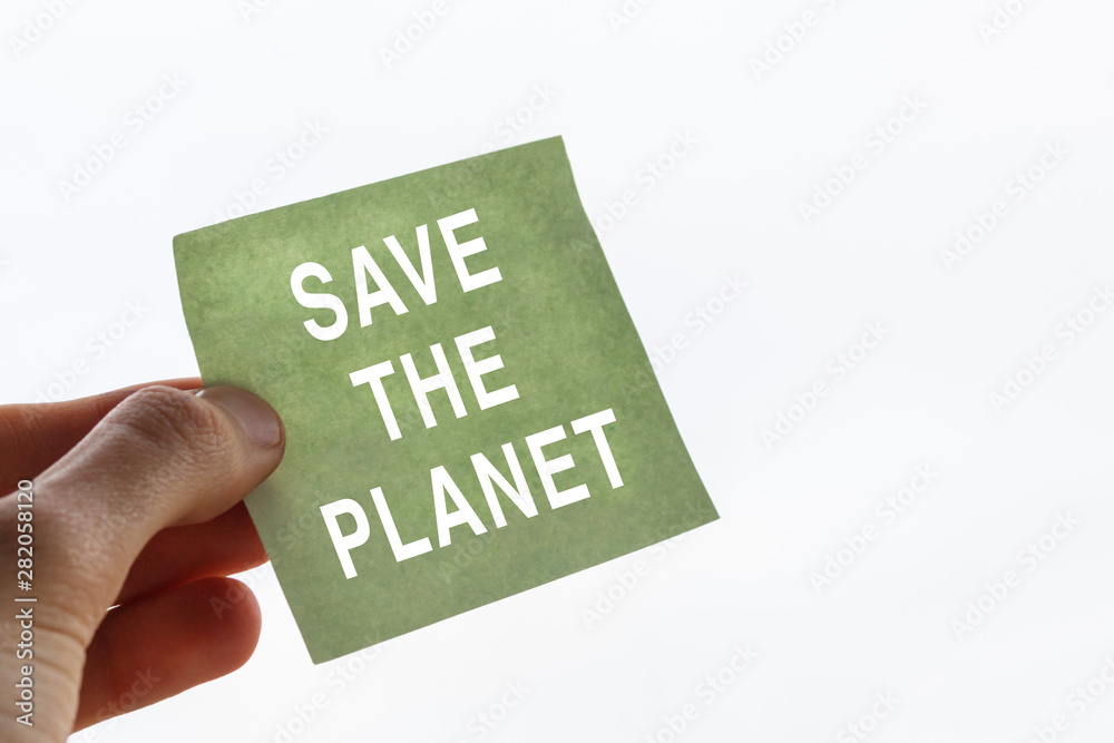 fingers of a teenager hold sticker with call to save the planet. white inscription save the planet in the male hand. The Concept of ecology fingers of a teenager hold sticker with call to save the planet. white inscription save the planet in the male hand. The Concept of ecology