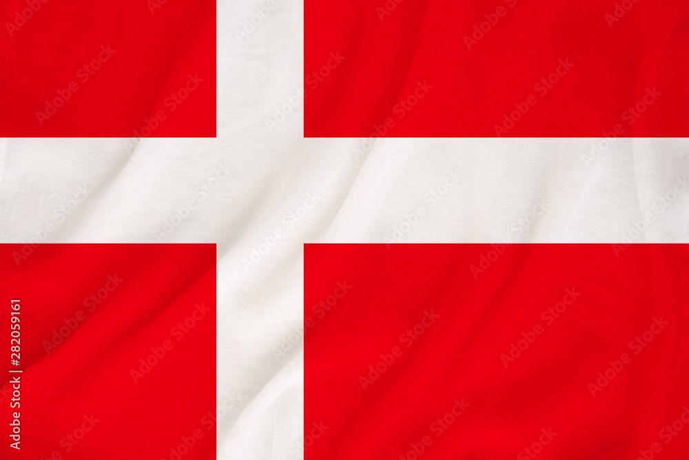 The national flag of the country of Denmark on the gentle silk with folds from the wind, the concept of travel, immigration, politics, copy space, close-up The national flag of the country of Denmark on the gentle silk with folds from the wind, the concept of travel, immigration, politics, copy space, close-up