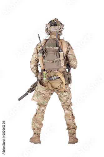 Armed army soldier standing backwards studio shoot
