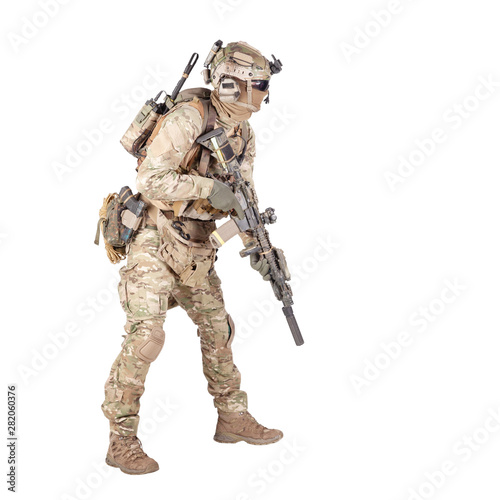 Army soldier crouching with rifle studio shoot