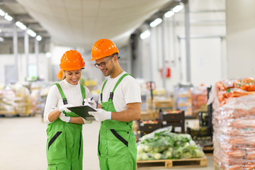 Young people in protective uniform working at organic food distr