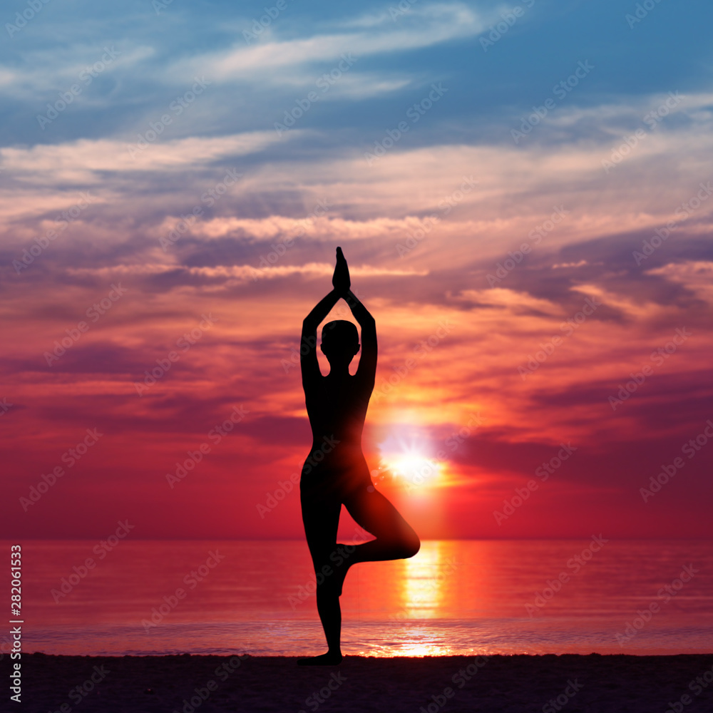 Silhouette of Woman Meditating in Yoga pose by the Sea at Sunset. Nature Meditation Concept. Low key photo. relax time - obrazy, fototapety, plakaty 