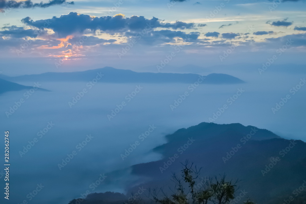 Mountain view misty morning of top hills around with sea of mist with cloudy sky background, sunrise at Pha Tang, Chiang Rai, northern of Thailand.