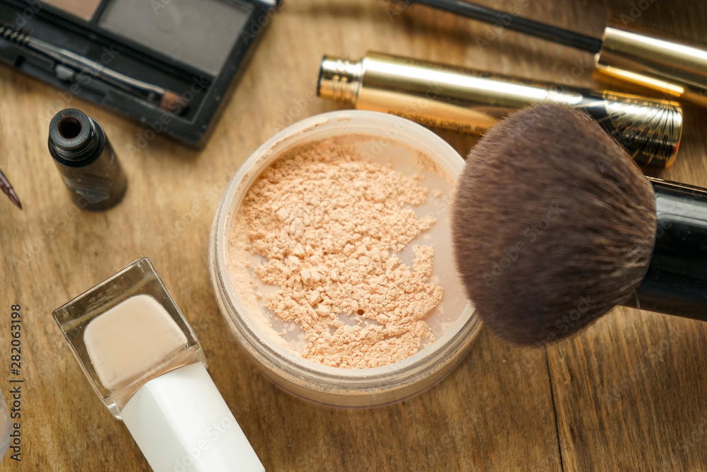 selective focus, layout, a set of women's cosmetics, light powder with a large brush, eyebrow shadow with a brush, black mascara, beige nail Polish, brown eyeliner selective focus, layout, a set of women's cosmetics, light powder with a large brush, eyebrow shadow with a brush, black mascara, beige nail Polish, brown eyeliner