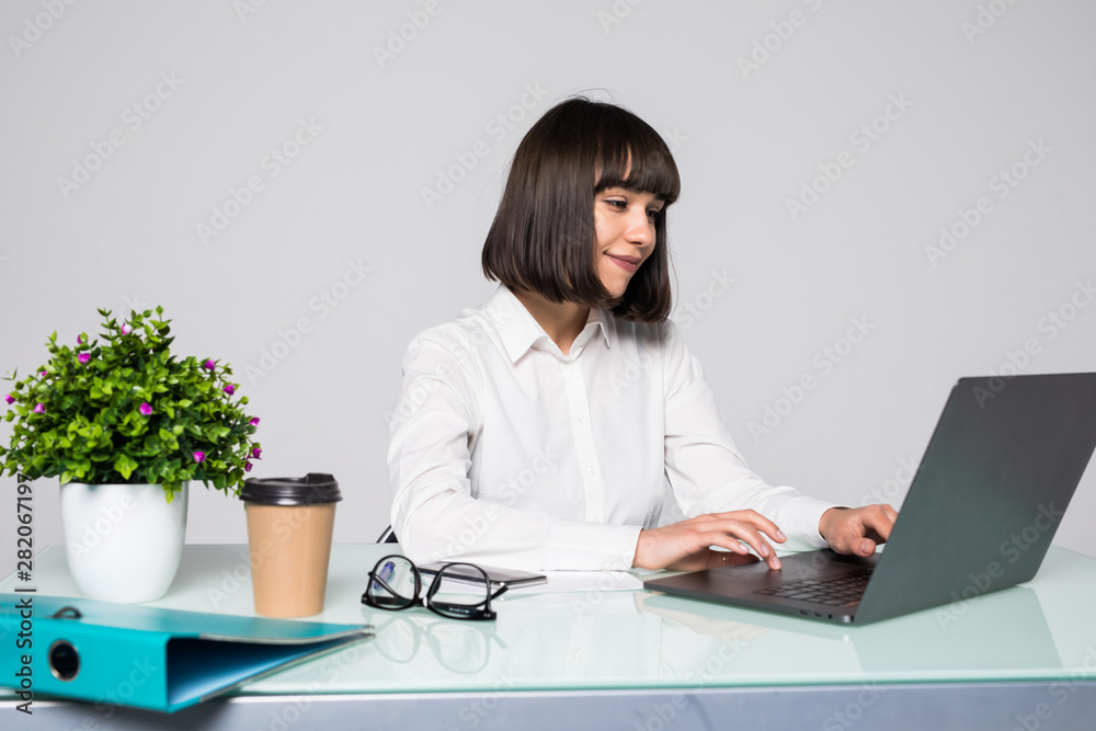 Young beautiful businesswoman working on laptop in bright modern office Young beautiful businesswoman working on laptop in bright modern office