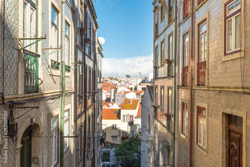 Glazed tile house facade and urban canyon and a view down to the city of Lisbon