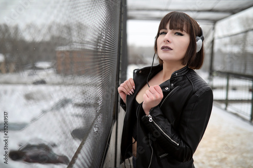Girl in headphones listening to music outdoors © alexkich
