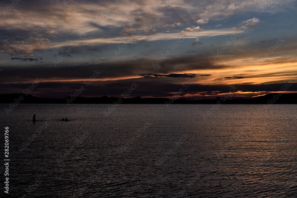 Fototapeta premium lake Balaton sunset, people silhouette, Plattensee - dark tones