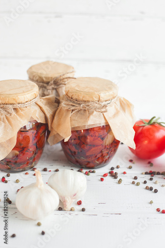 Tomatoes in the jar. Homemade sun dried tomatoes. temporary closing-down. Summer and autumn canned food. conserve with spices and vegetables. photo