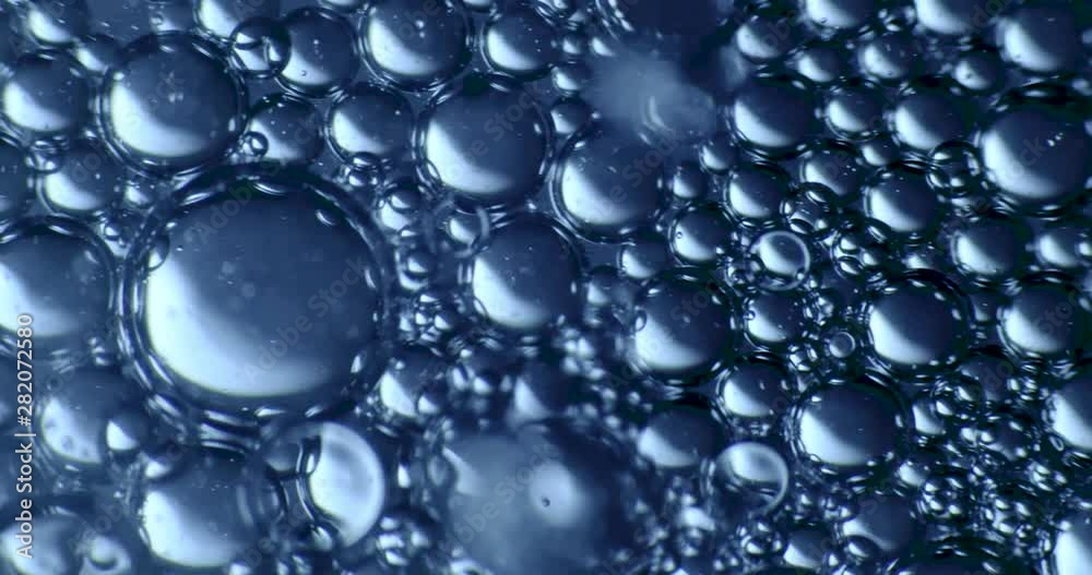 Color drops floating in oil and water over a colorful background Color drops floating in oil and water over a colorful background