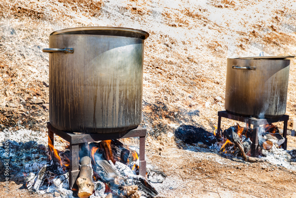 dos grandes ollas de hierro cocinando sobre un fuego de leña para una  comida en el campo Stock Photo | Adobe Stock