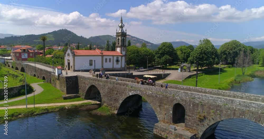 Aerial Forward Slow: People Passing By Small Bridge in Ponte De Lima With View of Amazing Area - Ponte de Lima, Portugal