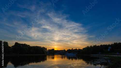 Panorama of the evening sky with clouds in Yaroslavl. The setting sun is reflected in the water of the Kotorosl River.