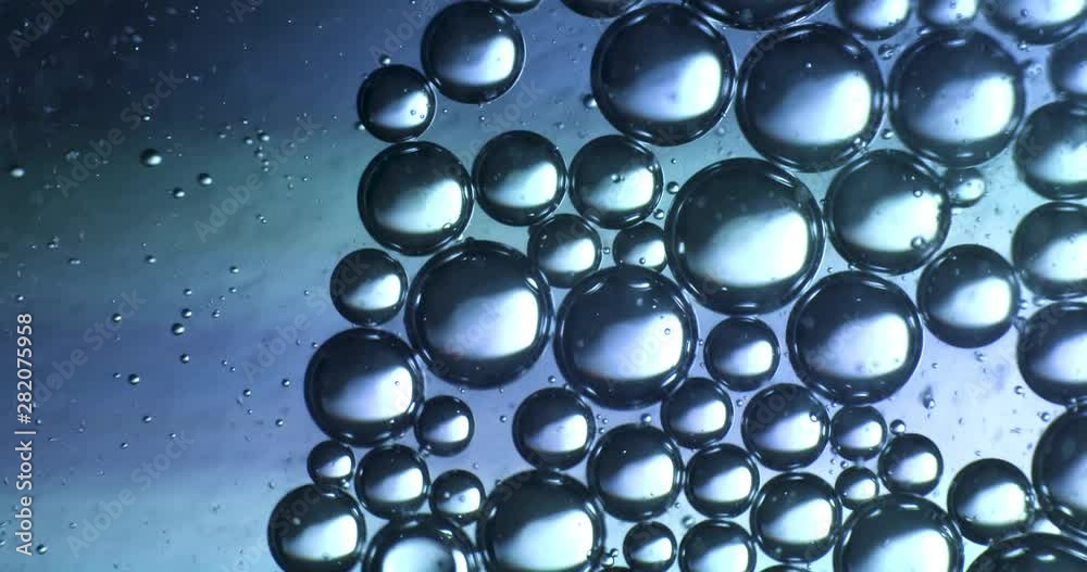 Color drops floating in oil and water over a colorful background Color drops floating in oil and water over a colorful background
