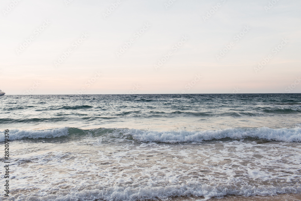 Beautiful tropical beach and water view with  blue sea or ocean with waves on Phuket, Thailand. Minimal composition with punchy colors. Summer concept. Natural background.